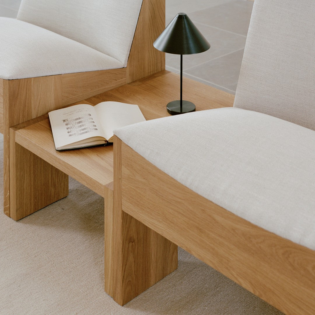 Light beige upholstered seating with natural oak wood accents, featuring minimalistic design and smooth textures.