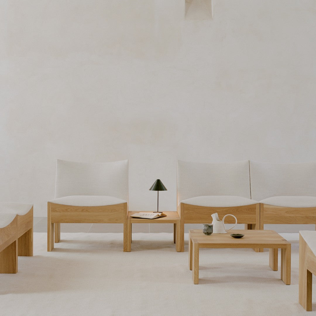 Minimalist beige chairs with light wooden frames, set against a soft cream backdrop, creating a serene, modern aesthetic.