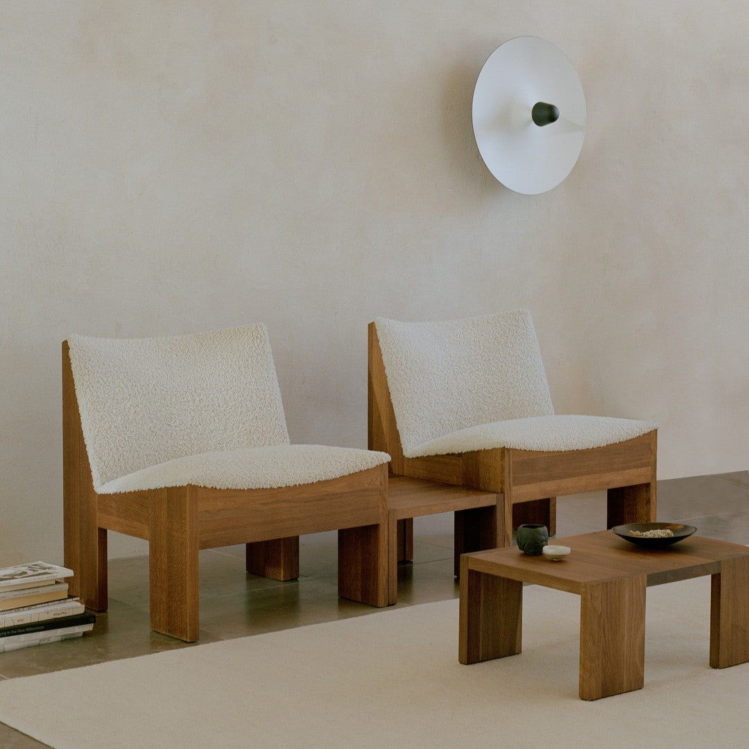 Beige and cream upholstered chairs with textured fabric against a neutral background and wooden accents.