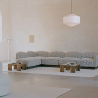 Modern sectional sofa with a beige and black leopard print pattern, in a minimalist interior setting.