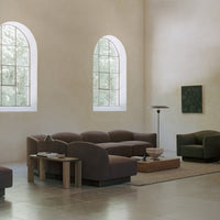 Modern living room with brown furniture, muted green accents, and soft beige walls, featuring neutral tones and natural textures.