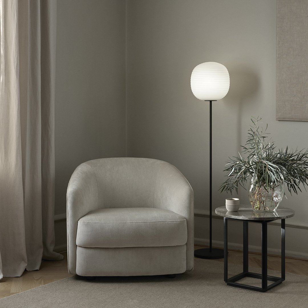 Cozy light gray upholstered chair in a minimalist setting with soft, neutral tones and elegant textures.