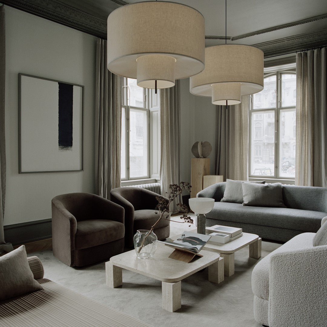 Modern living room featuring neutral tones, textured fabrics, and soft earth hues with minimalistic patterns.