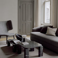 Modern living room featuring gray tones, textured fabrics, and black marble accents for a sleek, sophisticated look.