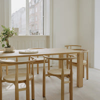 Minimalist wooden table and chairs in natural tones, featuring light beige and soft, neutral accents.