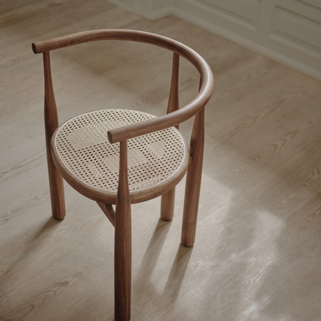 Natural wood chair with a round cane seat, featuring a light tan color and a woven texture pattern.
