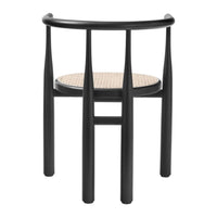 Black chair with slender legs and a natural woven seat, showcasing a stylish modern contrast of colors and textures.