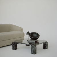 Gray sofa with a soft texture, sleek black marble coffee table, and elegant black lamp, creating a modern, minimalist vibe.