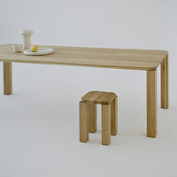 Natural wood grain table and stool with light beige tones, featuring a minimalist design against a white background.