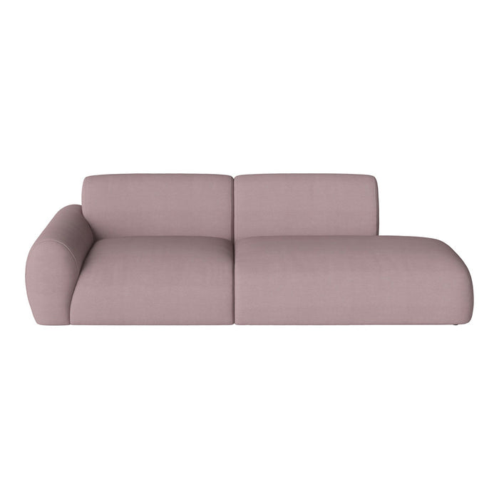 Soft pink upholstered sectional sofa with smooth, minimalistic design and rounded edges.
