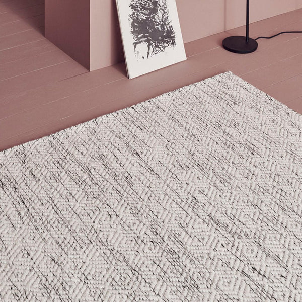 Textured area rug in soft gray with geometric patterns, perfect for modern decor.