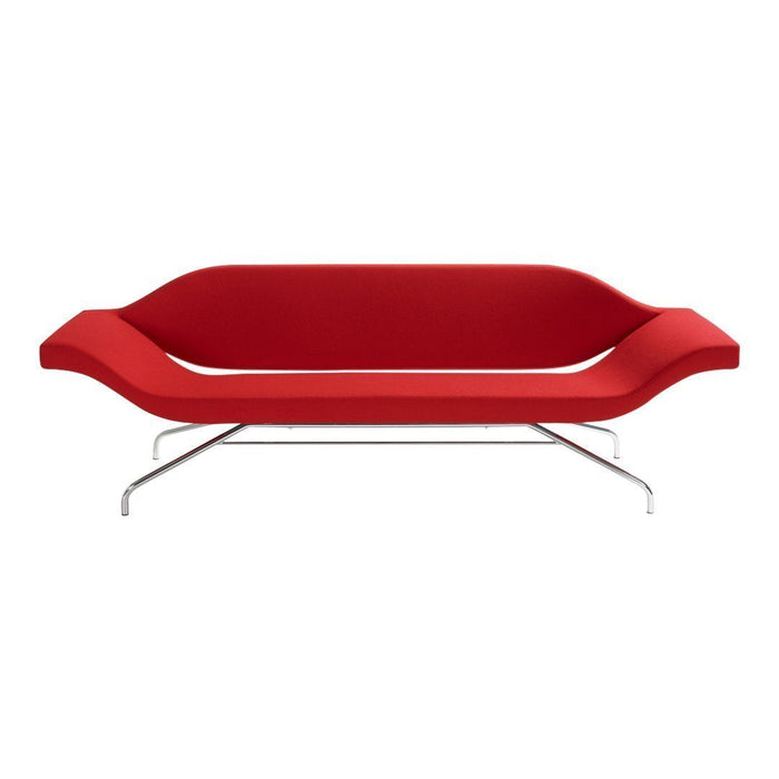 Modern red sofa with sleek design and smooth, curved contours on a chrome frame. Perfect for contemporary decor.