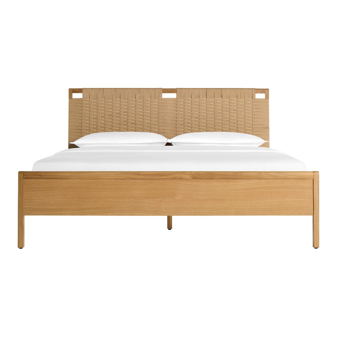Natural wood tones with a woven beige headboard and crisp white bedding. Modern, minimalist design.