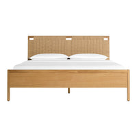 Natural wood tones with a woven beige headboard and crisp white bedding. Modern, minimalist design.