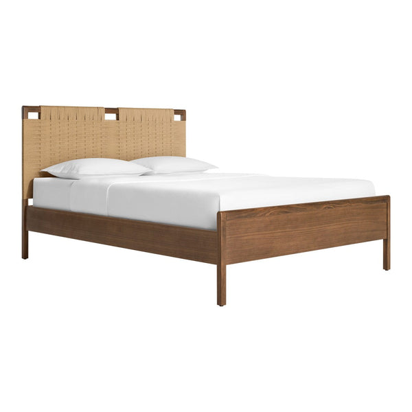 Natural wood tones with a woven tan fabric headboard and white bedding create a cozy, modern aesthetic.
