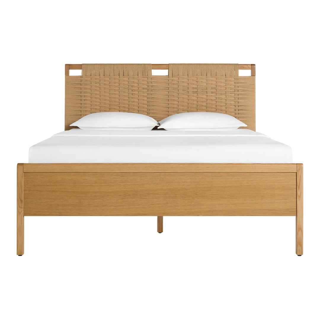 Natural wood bed frame with a woven tan headboard and crisp white bedding, highlighting earthy tones and modern design.