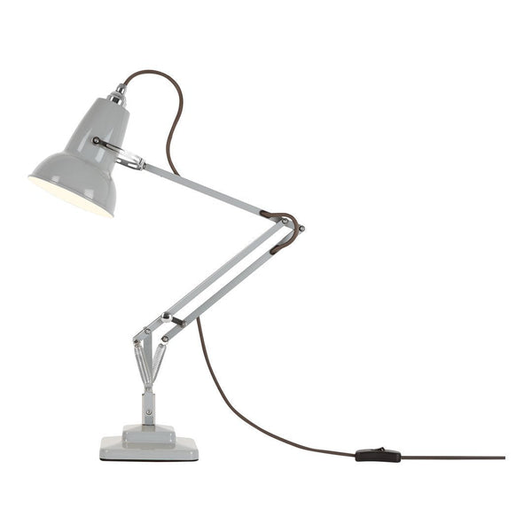 Gray desk lamp with a sleek metal finish and brown cord, featuring a minimalist design and adjustable arm.