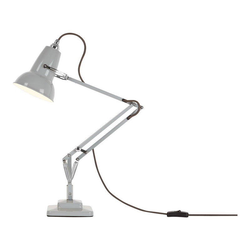 Gray desk lamp with a sleek metal finish and brown cord, featuring a minimalist design and adjustable arm.
