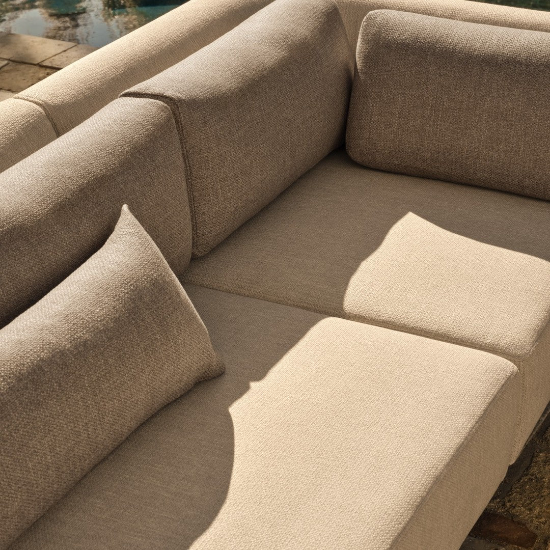 Beige sectional sofa with soft, textured fabric and matching cushions, ideal for modern and cozy interior designs.