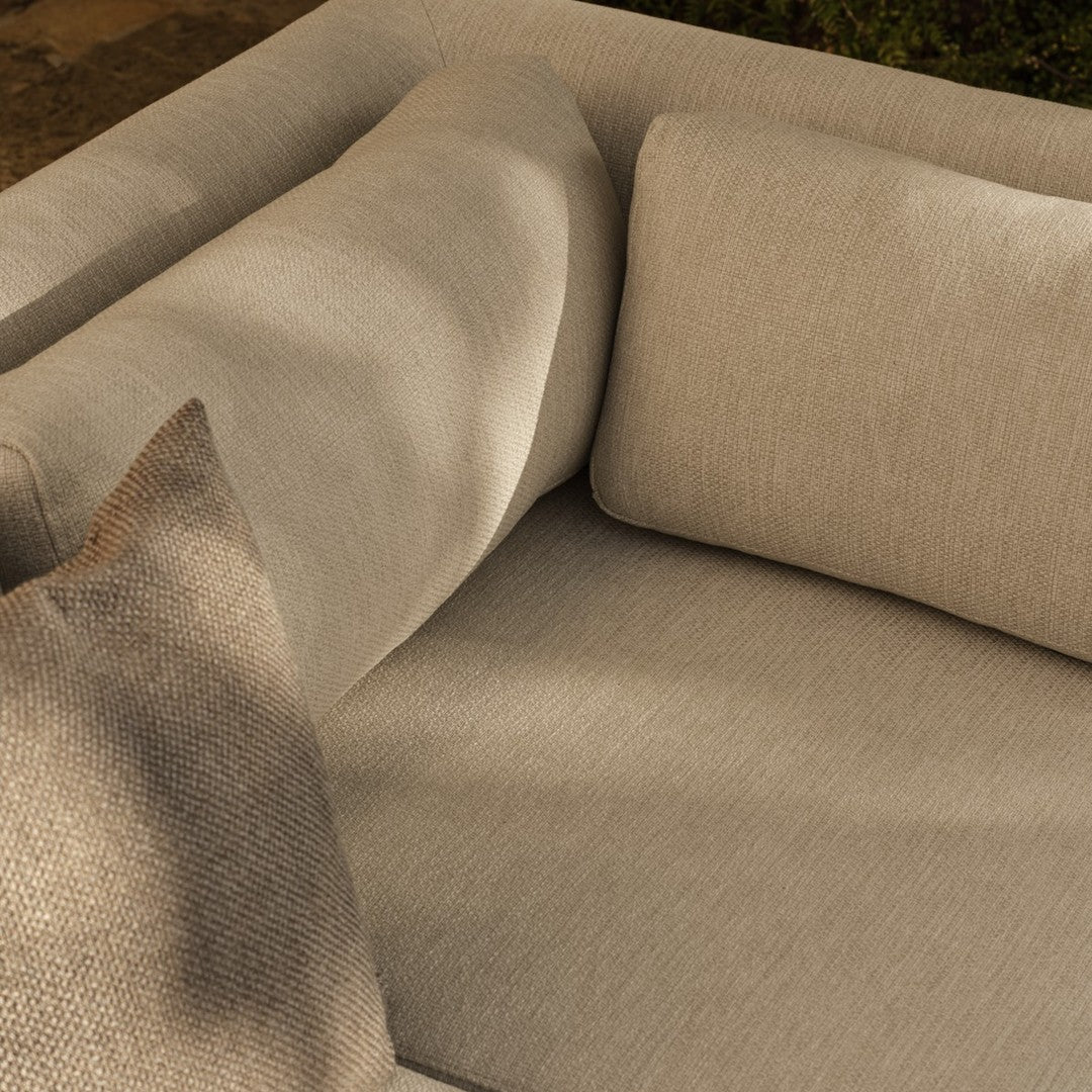 Beige textured sofa with soft cushions, featuring a subtle pattern on a complementary throw pillow. Perfect for modern decor.