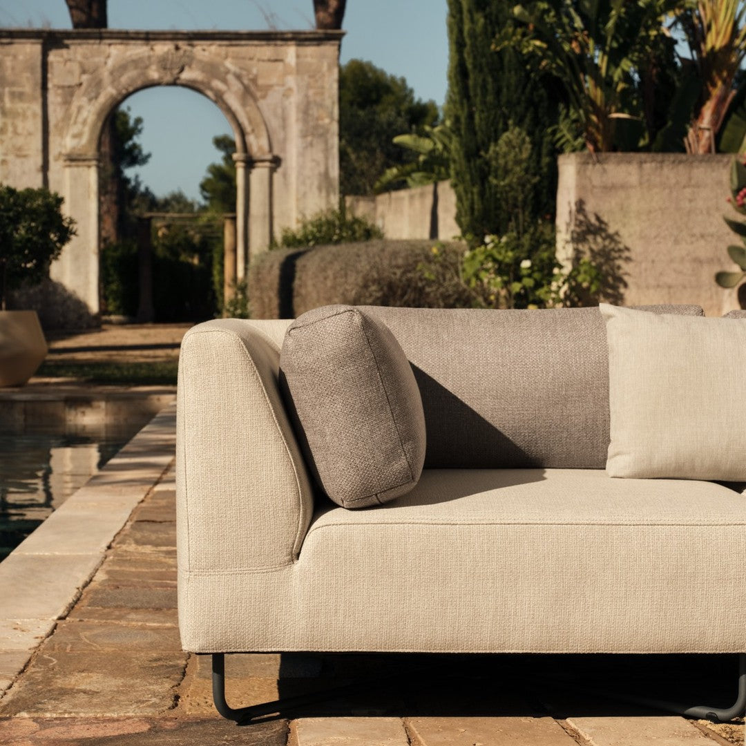Beige and gray sectional sofa with a modern design and soft textures, featuring a round cushion and sleek lines.