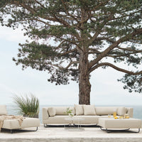 "Neutral beige outdoor sofa with clean lines, accented by textured cushions, set against a natural background."