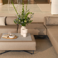 Beige sectional sofa with textured fabric, complemented by a gray coffee table and earthy decor accents.