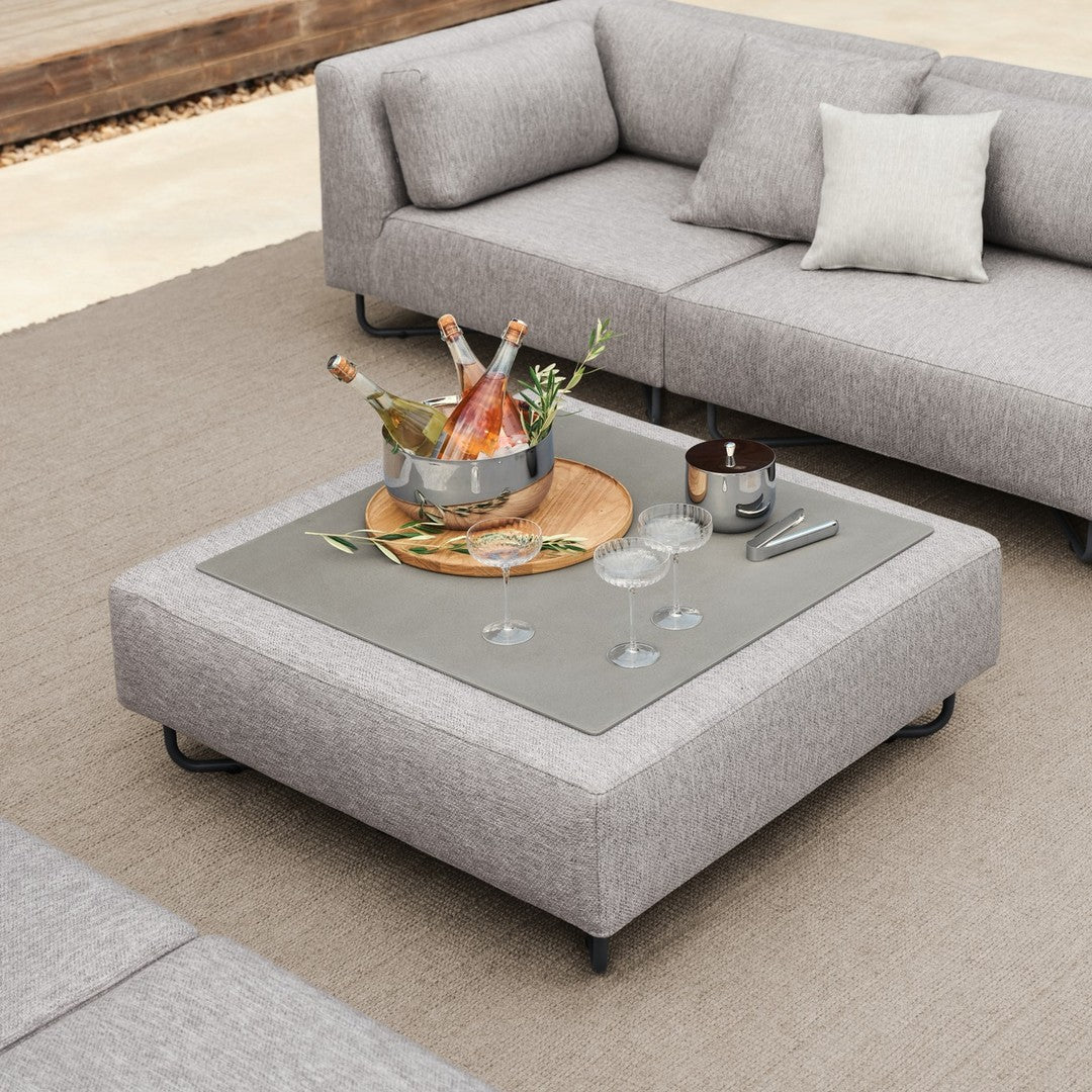Gray sectional sofa with textured fabric and a sleek rectangular coffee table featuring a glass surface.