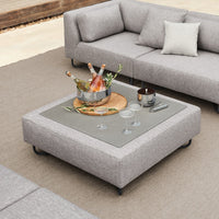 Gray sectional sofa with textured fabric and a sleek rectangular coffee table featuring a glass surface.