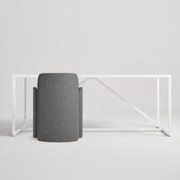 Modern gray fabric chair paired with a sleek white metal desk against a minimalist backdrop.
