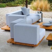 Light gray outdoor sofa with minimalist design, paired with wooden platform coffee tables. Elegant and modern aesthetics.