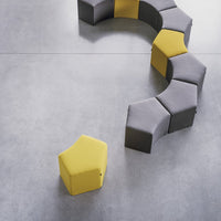 Modular seating in gray and bold yellow hexagonal patterns on a smooth gray surface.