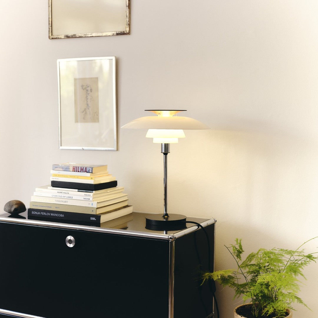 Modern table lamp with a soft white shade, black base, and warm gold accents, enhancing any décor with elegance.