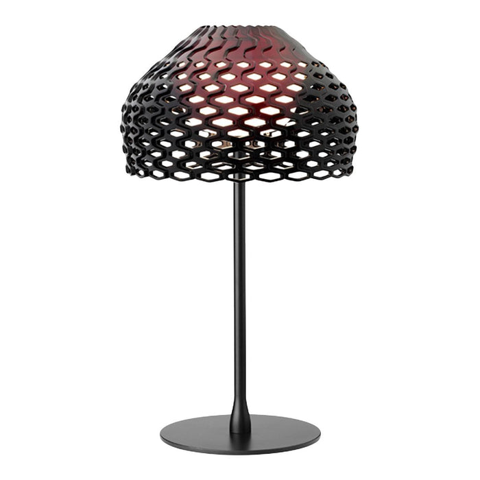 Black lamp with a unique honeycomb pattern and a warm red glow. Elegant and modern design for stylish decor.
