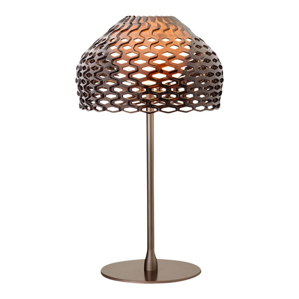 Bronze lamp with a unique honeycomb pattern, featuring warm amber light and a sleek base. Ideal for modern decor.