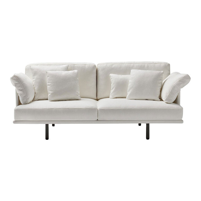 White modern sofa with plush cushions and sleek black legs, creating a clean and minimalist design.