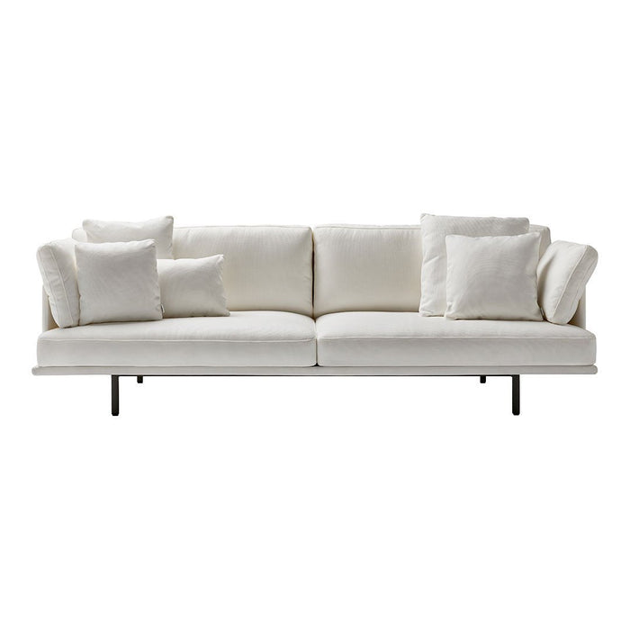 Elegant white sofa with soft texture and matching plush cushions, featuring a minimalist design and sleek black legs.