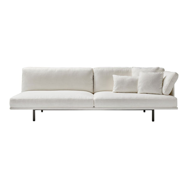 Modern white sofa with textured fabric and plush pillows, featuring a minimalist design and sleek metal legs.