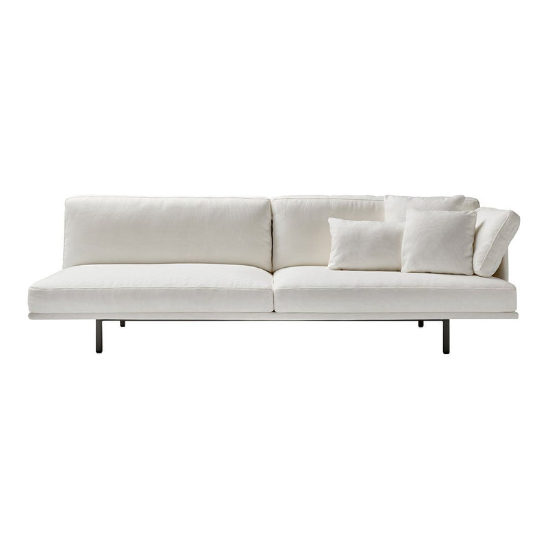 Modern white sofa with textured fabric and plush pillows, featuring a minimalist design and sleek metal legs.