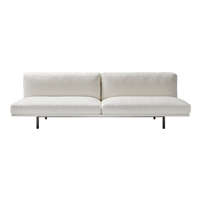 Modern white sofa with sleek cushions and a minimalist design, featuring a solid black metal base.
