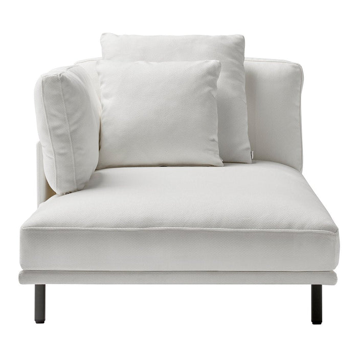 Contemporary white chaise lounge with plush white pillows and sleek black legs, featuring a minimalist design.
