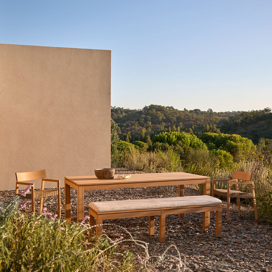 Elegant wooden outdoor furniture set in natural tones, featuring clean lines and a minimalist design against a serene landscape.