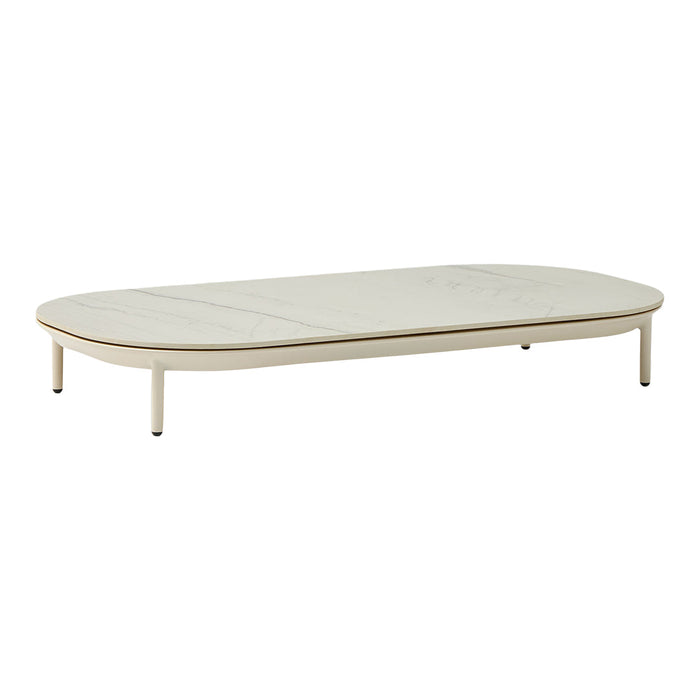 Modern oval coffee table in soft cream with a smooth surface and minimalist design, featuring natural wood accents.
