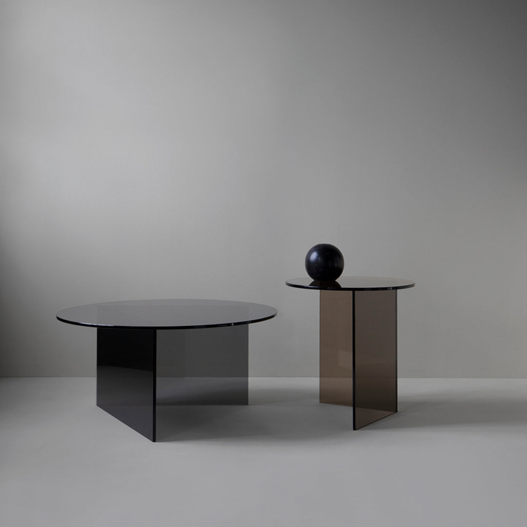 Stylish round coffee tables in black and brown glass, featuring sleek geometric patterns and modern design.