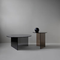 Stylish round coffee tables in black and brown glass, featuring sleek geometric patterns and modern design.