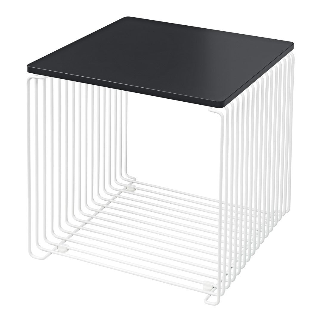 Modern black tabletop with white wireframe base, creating a sleek contrast in color and geometric pattern.