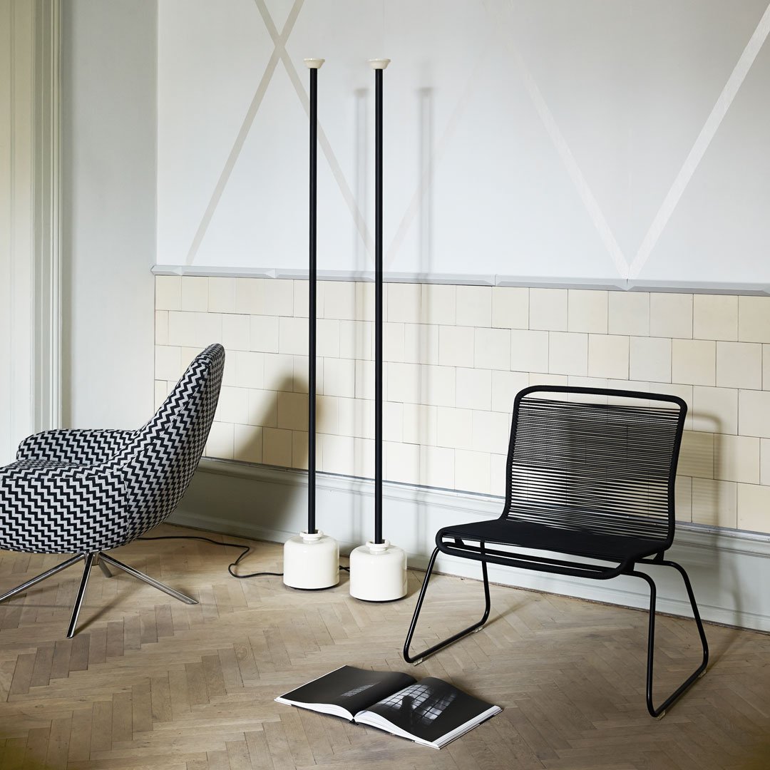 Black and white geometric patterns with sleek black metal and soft beige tones in a modern interior setting.