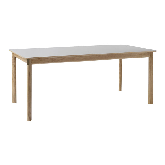 Wooden dining table with a light brown finish and a smooth white top, featuring a minimalist design.