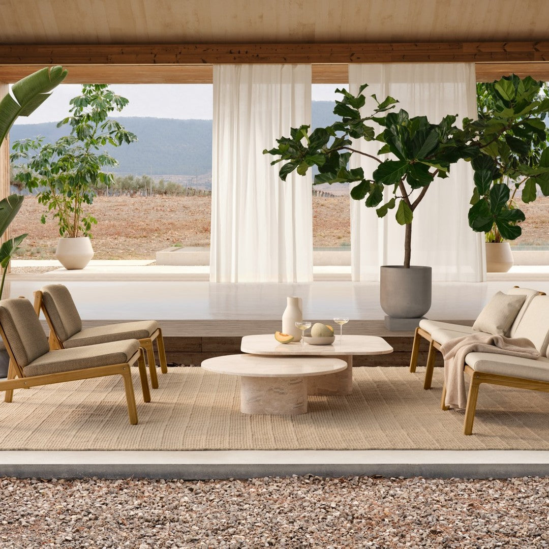Stylish outdoor seating in neutral tones with beige cushions, natural wood accents, and a soft round coffee table.