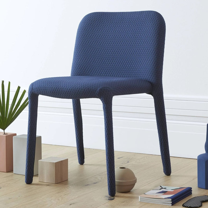 Navy blue, textured chair with smooth lines, perfect for modern interiors. Ideal for dining or office spaces.